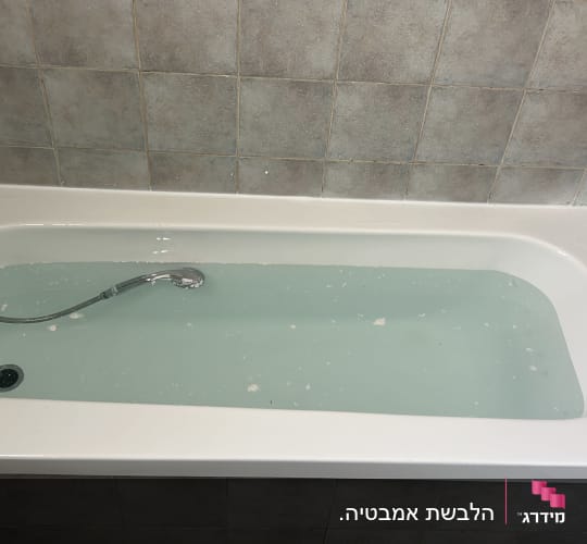 אמבטיה עם מים וקירות מחופים באריחים
